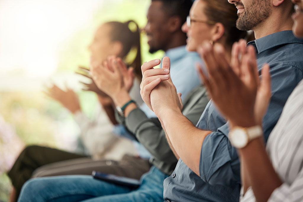 Connected - image of multiple people sitting and clapping their hands